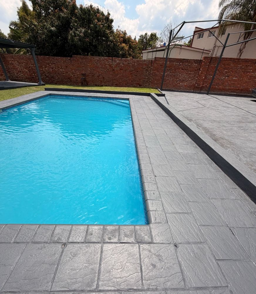 Swimming pool surrounded by grey stone paving