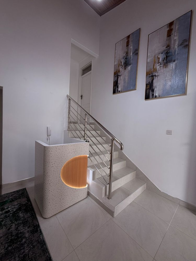 Reception desk beside the staircase with abstract artwork